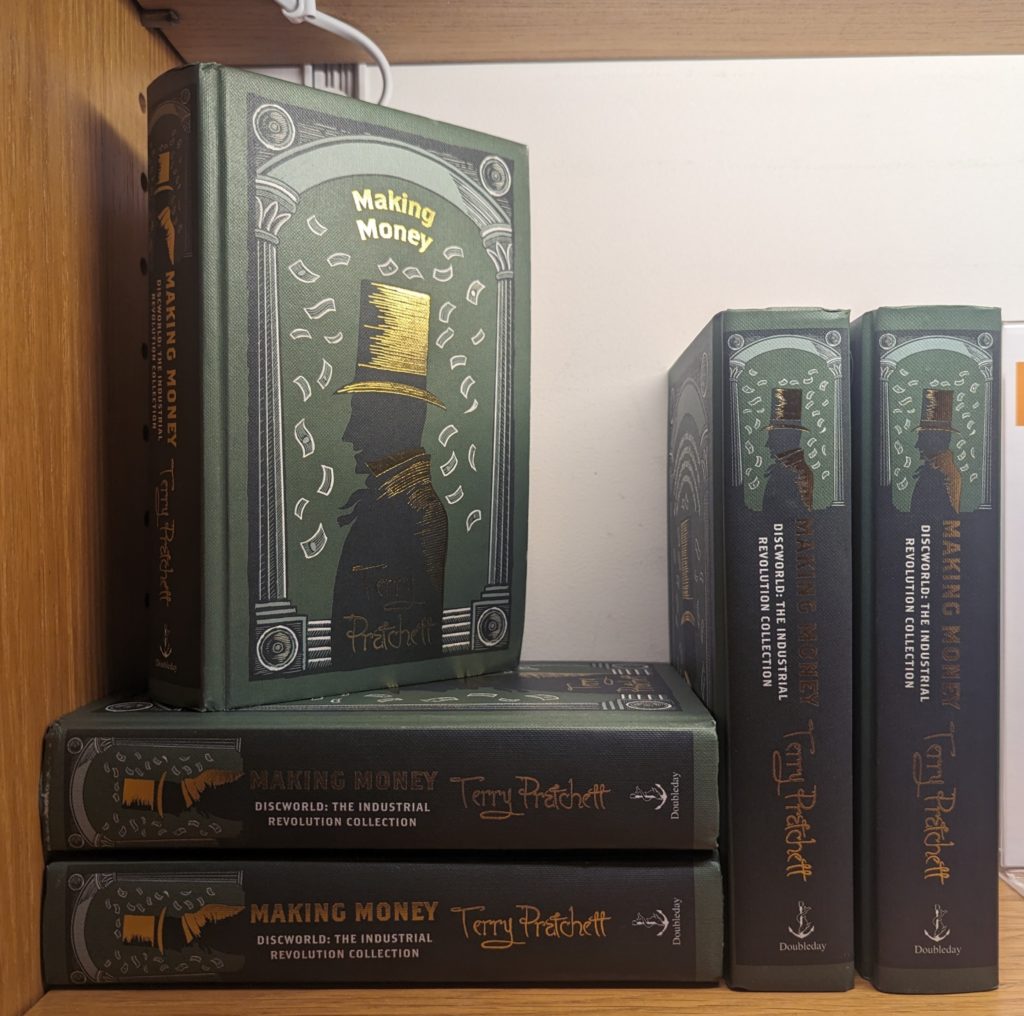 A bookshelf full of Terry Pratchett's "Making Money"